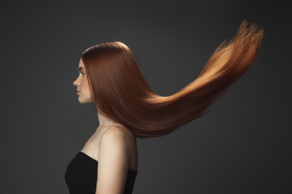 beautiful_model_with_long_smooth_flying_red_hair_isolated_dark.jpg